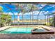 Screened in pool and spa offer a private retreat with views of the lush landscaping and clear blue sky at 4015 La Costa Island Ct, Punta Gorda, FL 33950