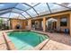 Screened-in pool and spa with patio seating area. Exterior also features a grill, great for outdoor entertainment at 4015 La Costa Island Ct, Punta Gorda, FL 33950