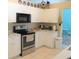 Bright kitchen featuring white cabinets, stainless steel appliances, and an adjacent breakfast nook at 4309 Badali Rd, North Port, FL 34286