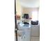 Functional laundry room featuring a washer and dryer with storage shelves at 4309 Badali Rd, North Port, FL 34286