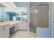 Bathroom with large mirror, vanity area, white cabinets, shower, and blue walls and tile flooring at 5720 Almar Dr, Punta Gorda, FL 33950