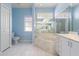 Bathroom with blue walls, tile floor, large mirror, tub, toilet, and multiple windows for natural light at 5720 Almar Dr, Punta Gorda, FL 33950