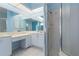 Bathroom with large mirror, vanity area, white cabinets, shower, and blue walls and tile flooring at 5720 Almar Dr, Punta Gorda, FL 33950