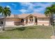 Well-maintained home featuring a tiled roof, attached garage, and beautiful landscaping at 5720 Almar Dr, Punta Gorda, FL 33950