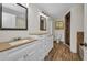 Bright bathroom featuring double vanities, wood-look flooring, and a separate water closet at 6405 Alan Blvd, Punta Gorda, FL 33982