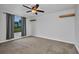 A vacant bedroom includes grey carpet, a window with gray curtains, and a ceiling fan at 6405 Alan Blvd, Punta Gorda, FL 33982