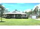 Charming single-story home with covered porch, green lawn and a detached garage or shed on a sunny day at 6405 Alan Blvd, Punta Gorda, FL 33982