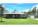 Inviting single-story home with a covered porch, manicured lawn, and a detached garage or shed on a sunny day at 6405 Alan Blvd, Punta Gorda, FL 33982