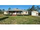 Inviting home featuring a covered front porch, lush lawn, and detached garage at 6405 Alan Blvd, Punta Gorda, FL 33982