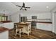 Bright kitchen featuring vaulted ceiling, island with seating, white cabinets, stainless appliances, and wood counters at 6405 Alan Blvd, Punta Gorda, FL 33982