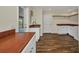 Bright laundry room features wood counters, white cabinets, open shelving, sink, and access to porch at 6405 Alan Blvd, Punta Gorda, FL 33982