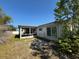 View of the screened porch of this house with overgrown grass at 8782 La Boca Ave, North Port, FL 34287