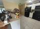 Galley-style kitchen featuring white cabinets, an electric range, and tile flooring at 8782 La Boca Ave, North Port, FL 34287