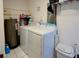 Bright laundry room featuring white washer and dryer, water heater, and tiled floor at 8795 56Th N St, Pinellas Park, FL 33782
