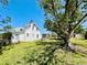 A side view of the white house with a large tree that shades the backyard at 899 S Broadway, Englewood, FL 34223