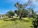 The property features a large, grassy backyard with mature trees, ideal for outdoor enjoyment at 899 S Broadway, Englewood, FL 34223