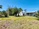 A spacious backyard with lush greenery and a white home that includes a large, screened porch area at 899 S Broadway, Englewood, FL 34223