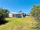 A backyard featuring a two-story home with screened in porch and partial tree coverage at 899 S Broadway, Englewood, FL 34223