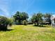 Lush backyard featuring mature trees, a partial fence, and ample room for outdoor relaxation and activities at 899 S Broadway, Englewood, FL 34223