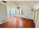 Bedroom featuring hardwood floors and natural light from the windows with light-colored curtains at 899 S Broadway, Englewood, FL 34223