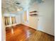 Bedroom with ceiling fan, hardwood floors, and unique cloud-painted ceiling design at 899 S Broadway, Englewood, FL 34223