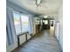Bright living area with wood look tile flooring, a ceiling fan and large windows with natural light at 899 S Broadway, Englewood, FL 34223