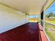 Large screened in porch featuring red wooden floor and plenty of room for entertaining or relaxing at 899 S Broadway, Englewood, FL 34223