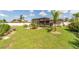 Spacious backyard with a pergola, seating area, and beautifully manicured lawn at 949 Springview Nw Ave, Port Charlotte, FL 33948