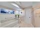 Bathroom featuring a soaking tub, tiled flooring, and grab bars for accessibility and safety at 949 Springview Nw Ave, Port Charlotte, FL 33948