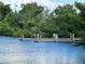 Waterfront property featuring a private dock extending into serene blue waters surrounded by lush greenery at 949 Springview Nw Ave, Port Charlotte, FL 33948