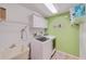 Well-equipped laundry room with modern washer and dryer, storage cabinets, and utility sink at 949 Springview Nw Ave, Port Charlotte, FL 33948