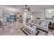 Open living room with neutral tones, wood-look tile floors, a ceiling fan, and a view into the adjacent kitchen and dining room at 949 Springview Nw Ave, Port Charlotte, FL 33948