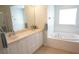 Well-lit bathroom featuring double sinks with vanity, and a tub with window at 98 Valdiva St, Punta Gorda, FL 33983