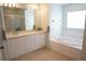 Well-lit bathroom featuring double sinks, vanity, and large bathtub at 98 Valdiva St, Punta Gorda, FL 33983