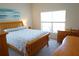 Comfortable bedroom with wooden furniture, a cozy bed, and a bright window at 98 Valdiva St, Punta Gorda, FL 33983