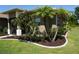 Beautiful Florida home with well-maintained landscaping, red flowers and lovely palm trees at 98 Valdiva St, Punta Gorda, FL 33983
