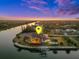 Waterfront home featuring an enclosed lanai, dock, and scenic sunset at 10580 Poughkeepsie Cir, Port Charlotte, FL 33981