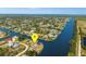 Scenic aerial view of a waterfront home with canal access, lush landscaping, and neighborhood setting at 10580 Poughkeepsie Cir, Port Charlotte, FL 33981