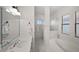 Bright and airy bathroom featuring a double vanity, soaking tub, walk-in shower, and tile flooring at 10580 Poughkeepsie Cir, Port Charlotte, FL 33981