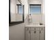 Bright bathroom featuring a mirror, undermount sink with white cabinets, and window at 10580 Poughkeepsie Cir, Port Charlotte, FL 33981