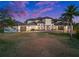 Stunning two-story home with a meticulously manicured lawn, palm trees, and a circular driveway at 10580 Poughkeepsie Cir, Port Charlotte, FL 33981