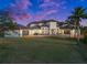 Elegant two-story home boasts a manicured lawn, tile roof, and multiple garages for ample parking at 10580 Poughkeepsie Cir, Port Charlotte, FL 33981