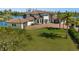 Luxury two-story home featuring a manicured lawn, tile roof, and a circular brick driveway at 10580 Poughkeepsie Cir, Port Charlotte, FL 33981