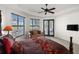 Bright main bedroom boasts a seating area, en-suite bath, and tray ceiling with fan at 10580 Poughkeepsie Cir, Port Charlotte, FL 33981