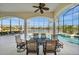 Covered and enclosed patio with waterfront views, a dining table, and ceiling fans at 10580 Poughkeepsie Cir, Port Charlotte, FL 33981