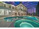 Enclosed pool area featuring hot tub, patio seating, and views from the upper balcony at 10580 Poughkeepsie Cir, Port Charlotte, FL 33981