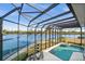 Screened-in pool area with lake views, patio seating, and a hot tub at 10580 Poughkeepsie Cir, Port Charlotte, FL 33981