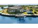 Waterfront home featuring an enclosed lanai, dock, and lush tropical landscaping at 10580 Poughkeepsie Cir, Port Charlotte, FL 33981