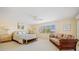 Spacious bedroom with a ceiling fan, sofa, floral bedspread, and natural light at 1326 Wesley Dr # 132, Punta Gorda, FL 33950