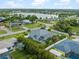 Aerial view of a home near a lake, highlighting the screened lanai, landscaping and neighborhood at 18652 Ohara Dr, Port Charlotte, FL 33948